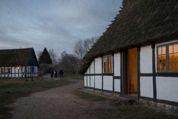 Children exploring a thatched historic farmhouse at Frilandsmuseet open-air museum near Lyngby